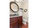 Bathroom features a dark wood vanity, gray countertop, round mirror and tiled floors at 9749 Soaring Eagle Ln, Fishers, IN 46055