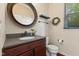 Bathroom features a dark wood vanity, gray countertop, round mirror, and tiled floors at 9749 Soaring Eagle Ln, Fishers, IN 46055