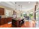 Sun-filled kitchen features dark wood cabinetry, granite countertops, kitchen island, and stainless steel appliances at 9749 Soaring Eagle Ln, Fishers, IN 46055