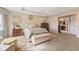 Comfortable primary bedroom with a seating area, tray ceiling, and adjacent bathroom at 9749 Soaring Eagle Ln, Fishers, IN 46055