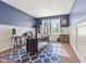 Home office boasts stylish blue walls, white wainscoting, and a plush patterned rug at 9749 Soaring Eagle Ln, Fishers, IN 46055