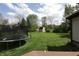 Spacious backyard with a trampoline, shed, and mature trees, ideal for outdoor activities at 9903 E Raymond St, Indianapolis, IN 46239