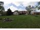 Spacious, grassy backyard with scattered vegetation and mature trees on a sunny day at 9903 E Raymond St, Indianapolis, IN 46239