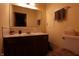 Bathroom with a vanity with a brown wood cabinet, mirror, and toilet with neutral paint at 9903 E Raymond St, Indianapolis, IN 46239