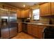 Updated kitchen features stainless steel appliances, wood cabinets, granite countertops, and wood floors at 9903 E Raymond St, Indianapolis, IN 46239