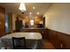 Kitchen and dining area features wood cabinets, stainless steel appliances, wood paneling, and a dining table at 9903 E Raymond St, Indianapolis, IN 46239