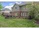 View of the home's backyard with a patio, fire pit, manicured lawn, and mature trees at 9950 Sugarleaf Pl, Fishers, IN 46038