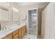 Bright bathroom features double sinks with light wood cabinetry, neutral countertops, and a shower at 9950 Sugarleaf Pl, Fishers, IN 46038