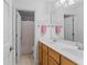 Bathroom featuring double sinks, wood cabinetry, neutral countertops, and a shower at 9950 Sugarleaf Pl, Fishers, IN 46038