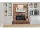 Cozy fireplace with a brick surround, built-in shelves, and decorative accents at 9950 Sugarleaf Pl, Fishers, IN 46038