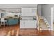 Eat-in kitchen with island and white cabinets, and nearby staircase at 9950 Sugarleaf Pl, Fishers, IN 46038