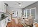 Bright living room with hardwood floors, two chairs, and view to the Gathering room and backyard at 9950 Sugarleaf Pl, Fishers, IN 46038