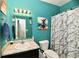 Cozy bathroom featuring teal walls, marble shower curtain, toilet, sink with vanity, and fun wall art at 998 Cass Dr, Franklin, IN 46131