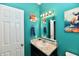 Vibrant half-bathroom with bright blue walls, modern sink, and unique wall art at 998 Cass Dr, Franklin, IN 46131