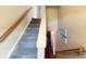 Carpeted staircase with natural wood trim connecting multiple levels of the home at 1026 Jackson St, Columbus, IN 47201
