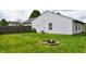 Grassy backyard with a fire pit and a view of the house's siding and windows at 107 Camelia Ct, Mooresville, IN 46158