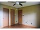 Bedroom featuring laminate floors, ceiling fan, and three wood doors at 107 Camelia Ct, Mooresville, IN 46158