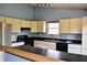 The kitchen showcases cream cabinets, dark countertops, black appliances and view of breakfast bar at 107 Camelia Ct, Mooresville, IN 46158