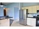An alternate view of the kitchen showcasing stainless steel refrigerator and a view into the living room at 107 Camelia Ct, Mooresville, IN 46158