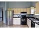 Kitchen featuring stainless steel appliances, cream cabinets, and dark countertop at 107 Camelia Ct, Mooresville, IN 46158