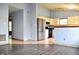 The living room with light blue walls and dark wood-look flooring leads into the kitchen with stainless refrigerator at 107 Camelia Ct, Mooresville, IN 46158