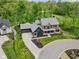 Aerial view of a two-story home with a three-car garage, circular drive and manicured landscaping at 11064 Hamilton Run, Zionsville, IN 46077