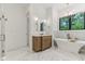 Bright bathroom featuring a soaking tub, vanity, marble floors and gold accents at 11064 Hamilton Run, Zionsville, IN 46077