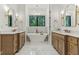Bright bathroom featuring a soaking tub, double vanity, marble floors and gold accents at 11064 Hamilton Run, Zionsville, IN 46077
