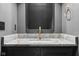 Bathroom vanity featuring a marble countertop, bronze faucet, and a dark wall at 11064 Hamilton Run, Zionsville, IN 46077