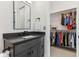 Bathroom vanity with dark countertop and closet with clothing at 11064 Hamilton Run, Zionsville, IN 46077
