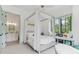 Serene bedroom with a canopy bed, a window seat, and an attached bathroom featuring decorative patterned tile flooring at 11064 Hamilton Run, Zionsville, IN 46077