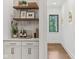 Butler pantry featuring white cabinets, open shelves, decor and a window looking outside at 11064 Hamilton Run, Zionsville, IN 46077