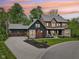 The front exterior of a large two-story home features a three-car garage and manicured landscaping at 11064 Hamilton Run, Zionsville, IN 46077