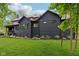 Rear exterior of the house showing the dark painted brick, various windows, and landscaped yard at 11064 Hamilton Run, Zionsville, IN 46077