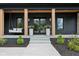 Inviting front porch with a swing, stylish columns, and elegant planters flanking the entrance at 11064 Hamilton Run, Zionsville, IN 46077