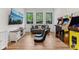 Well-lit game room features wood floors, classic arcade games, and an entertainment center at 11064 Hamilton Run, Zionsville, IN 46077