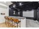 Home theater bar area with sleek countertops and a projector system with a starry night ceiling at 11064 Hamilton Run, Zionsville, IN 46077