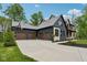 View of a house with a 3-car garage featuring a basketball hoop and mature landscaping at 11064 Hamilton Run, Zionsville, IN 46077