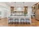 Large kitchen with a white island, wood cabinets, stainless steel appliances, and four stools at 11064 Hamilton Run, Zionsville, IN 46077