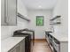 A contemporary laundry room with black washer/dryer, floating shelves, and sink with white countertop at 11064 Hamilton Run, Zionsville, IN 46077