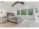 Inviting primary bedroom featuring vaulted ceilings, exposed wood beams, and backyard views at 11064 Hamilton Run, Zionsville, IN 46077