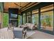 A covered patio features a stone fireplace, ceiling fan, and comfortable seating with views of the surrounding landscape at 11064 Hamilton Run, Zionsville, IN 46077