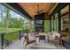 A covered patio offers golf course views, a stone fireplace, ceiling fan and comfortable seating with natural light at 11064 Hamilton Run, Zionsville, IN 46077