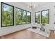 Sitting room with floor to ceiling windows, hardwood floors and two white chairs at 11064 Hamilton Run, Zionsville, IN 46077