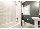 Modern bathroom featuring white subway tile, a shower-tub combo, and a pedestal sink at 1205 N Oxford St, Indianapolis, IN 46201