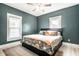 Cozy bedroom with dark teal walls, ceiling fan, and large windows at 1205 N Oxford St, Indianapolis, IN 46201