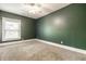 A carpeted bedroom featuring a ceiling fan, neutral carpet, base trim, and an exterior window at 1205 N Oxford St, Indianapolis, IN 46201