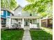 Charming two-story home boasts a welcoming front porch and well-maintained lawn with landscape at 1205 N Oxford St, Indianapolis, IN 46201