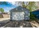 View of the garage with a white door and siding in the backyard at 1205 N Oxford St, Indianapolis, IN 46201