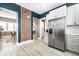 Modern kitchen featuring white cabinets, stainless steel appliances, subway tile backsplash, and exposed brick accent wall at 1205 N Oxford St, Indianapolis, IN 46201